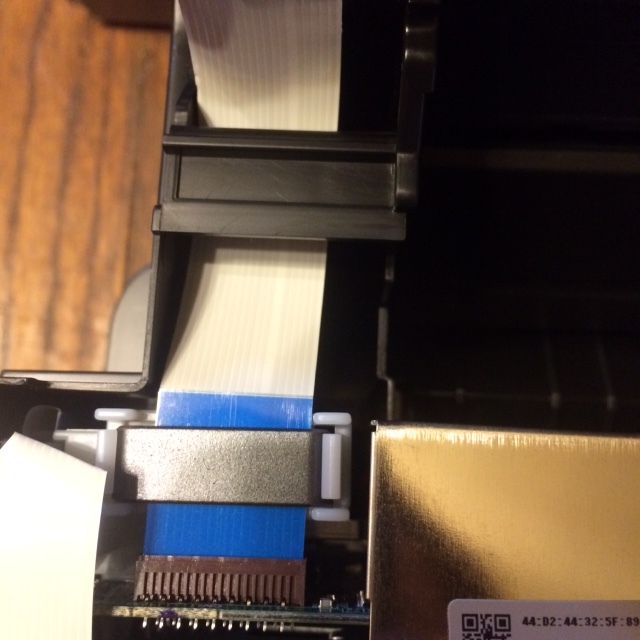 Disconnect the scanner flex cable under the top cover.